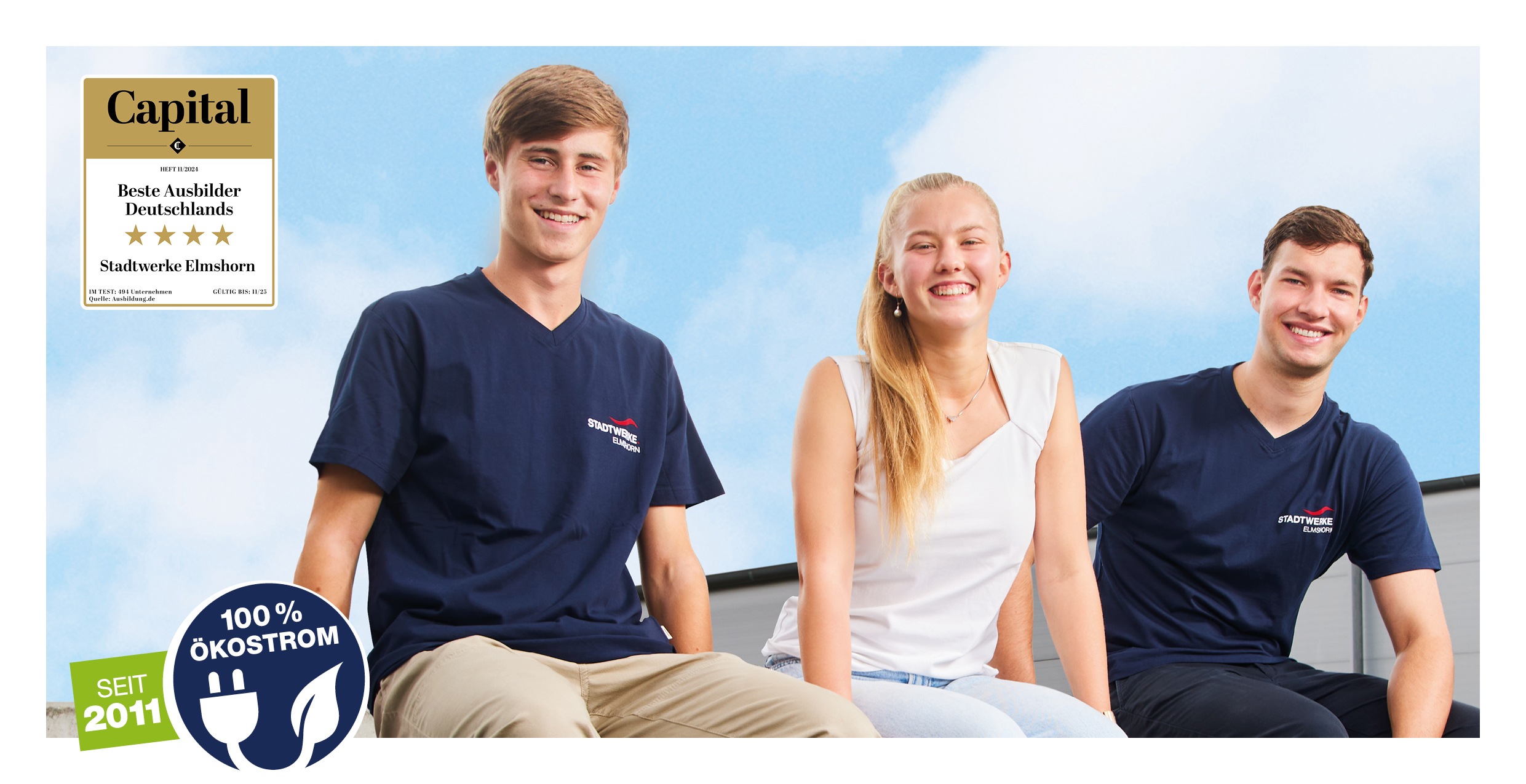 Drei junge Erwachsene in blauen T-Shirts sitzen lächelnd vor einem blauen Himmel. Links oben befindet sich ein Auszeichnungssiegel für die besten Ausbilder Deutschlands. Unten links ein Logo für 100 % Ökostrom.