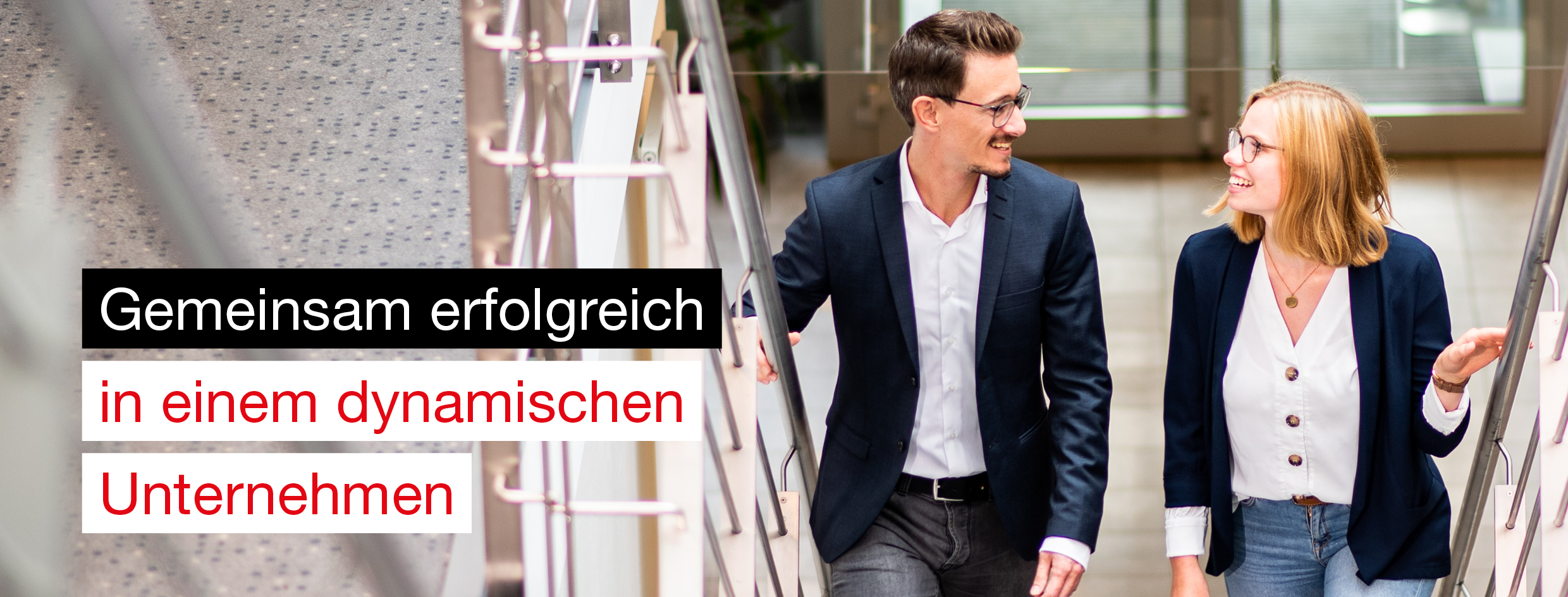 Junge, blonde Frau mit Brille und breitem L&auml;cheln schaut direkt in die Kamera. Sie tr&auml;gt einen dunkelblauen Blazer und steht in einem modernen Arbeitsumfeld. Links im Bild steht der Schriftzug 'Mach&rsquo;s wie ich.'